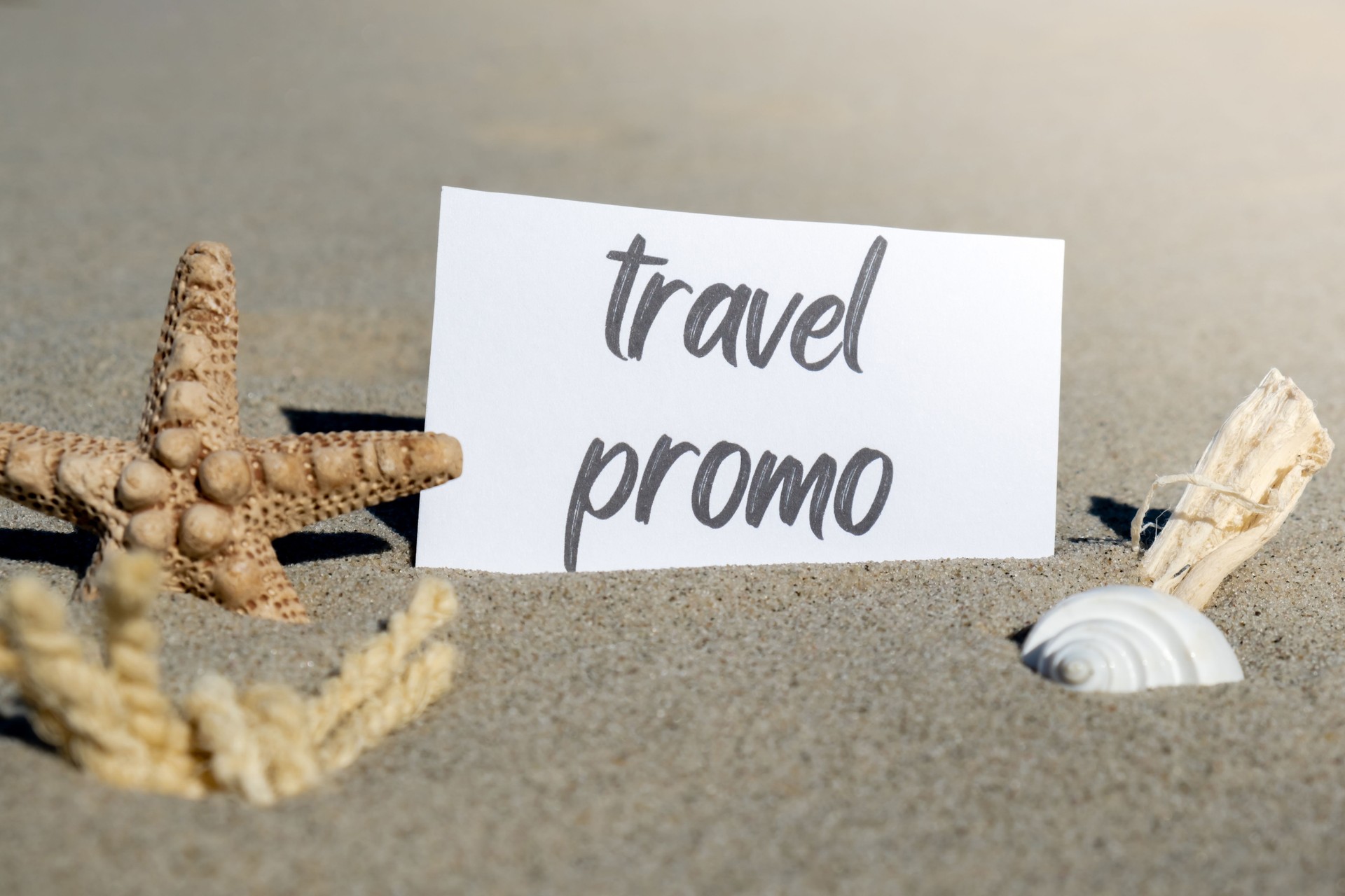 TRAVEL PROMO text on paper greeting card on background of starfish seashell summer vacation decor. Sandy beach sun coast. Holiday concept postcard. Getting away Travel