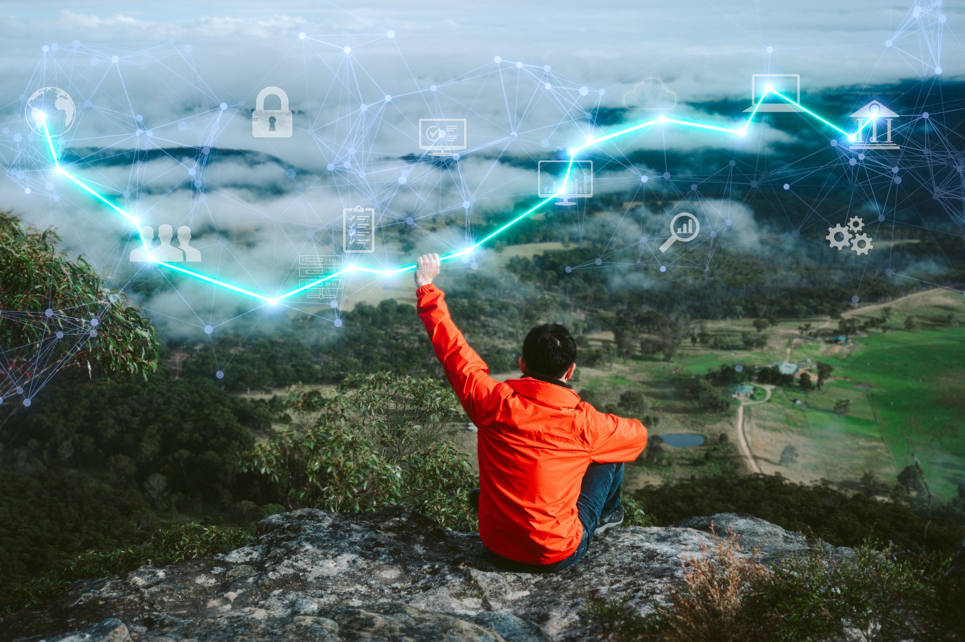 a man sitting on top of the mountain look out with virtual tech icons in concept of freelance digital transformation internet network and online marketing